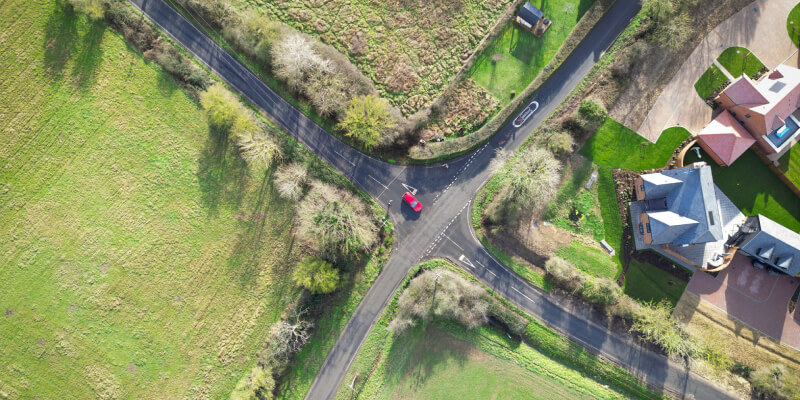 Aerial view of a car emerging from a crossroad junction