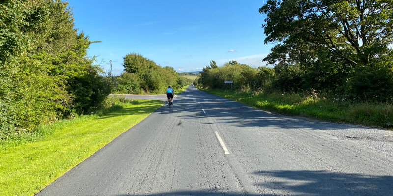 Country lane with a cyclist riding on the road
