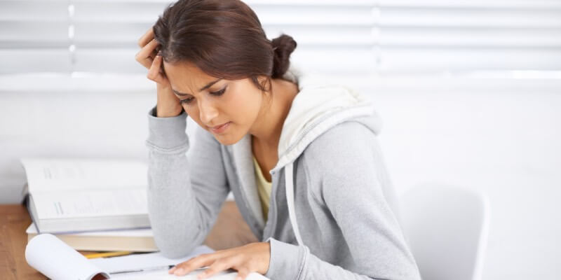 Woman looking down at paper with a confused expression